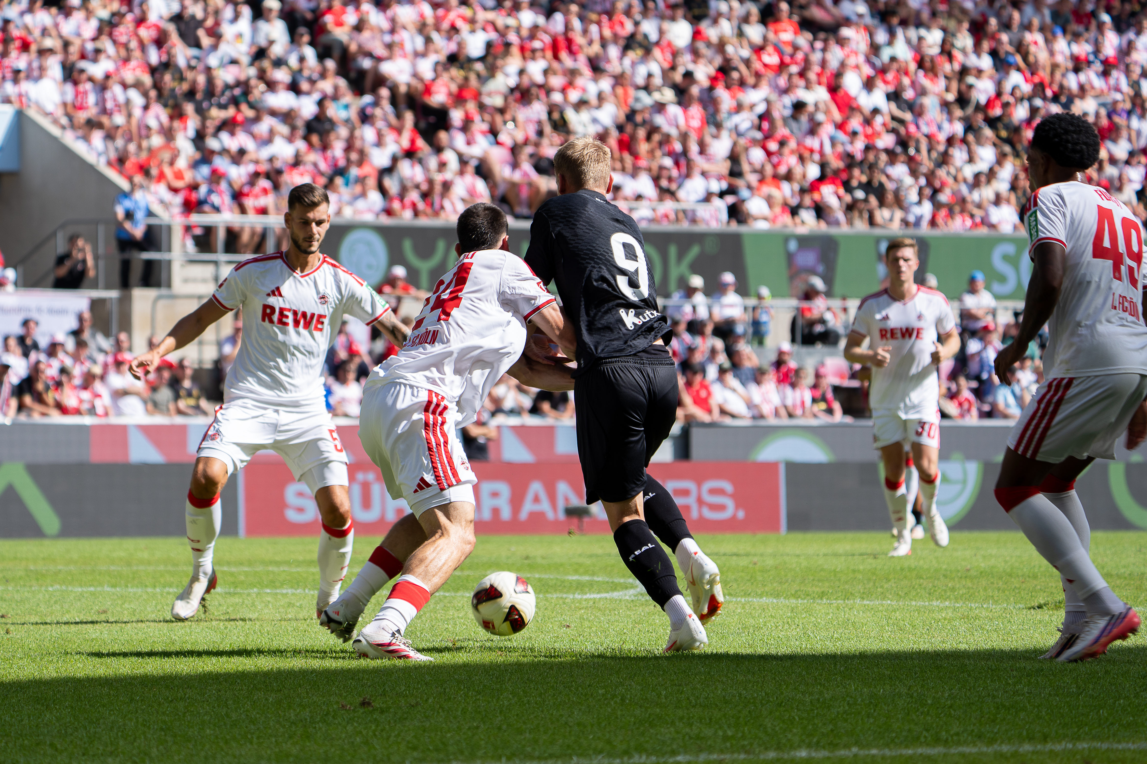 Ragnar Ache (#9; 1. FC Köln) im Zweikampf, umgeben von Mitspielern mit Rückennummern 24, 5 und 49, 1. FC Köln gegen Real Sociedad beim Freundschaftsspiel.
Foto: Alexander Franz