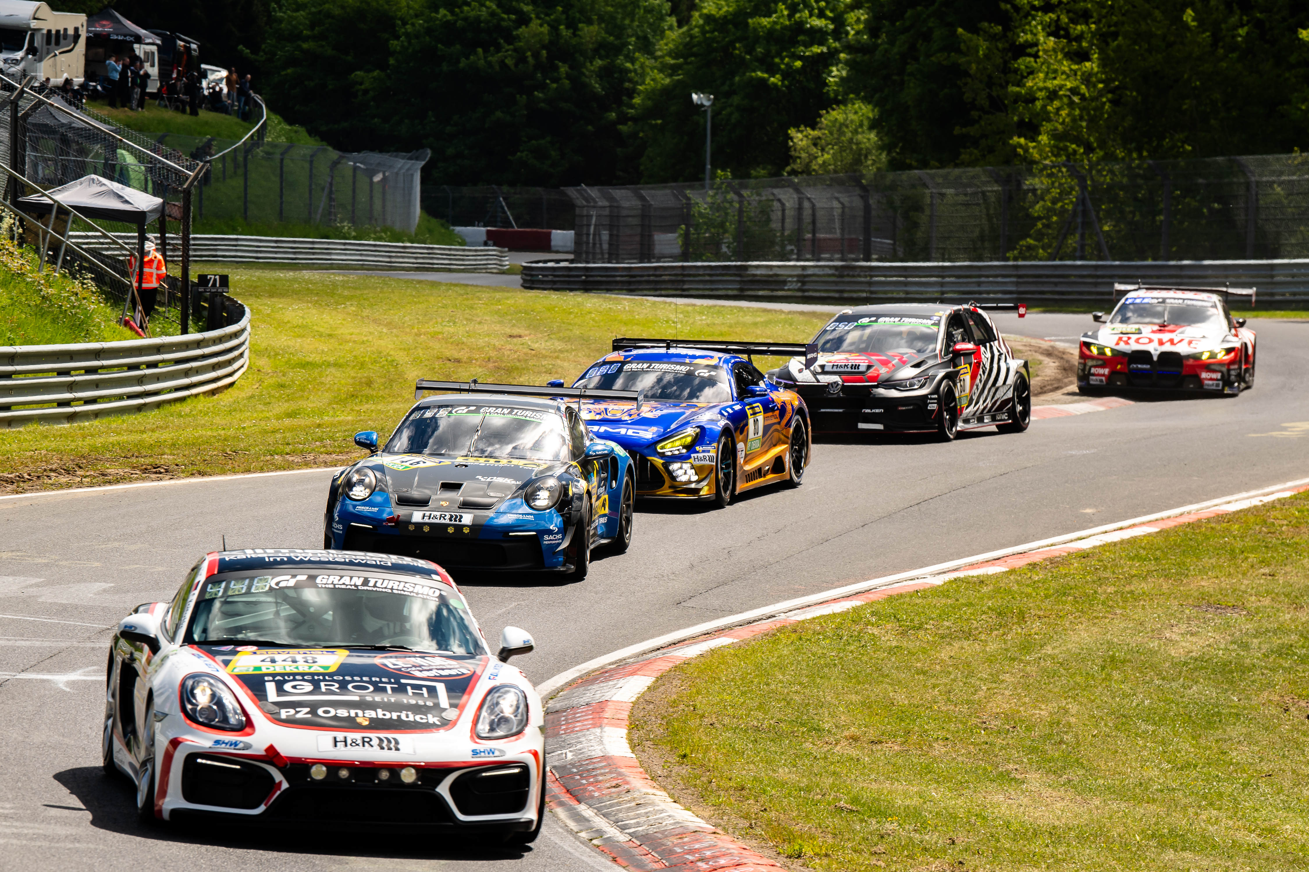 Mehrere GT-Rennwagen in einer Kurvenfahrt während des ADAC RAVENOL 24h Nürburgring GE Qualifying 1