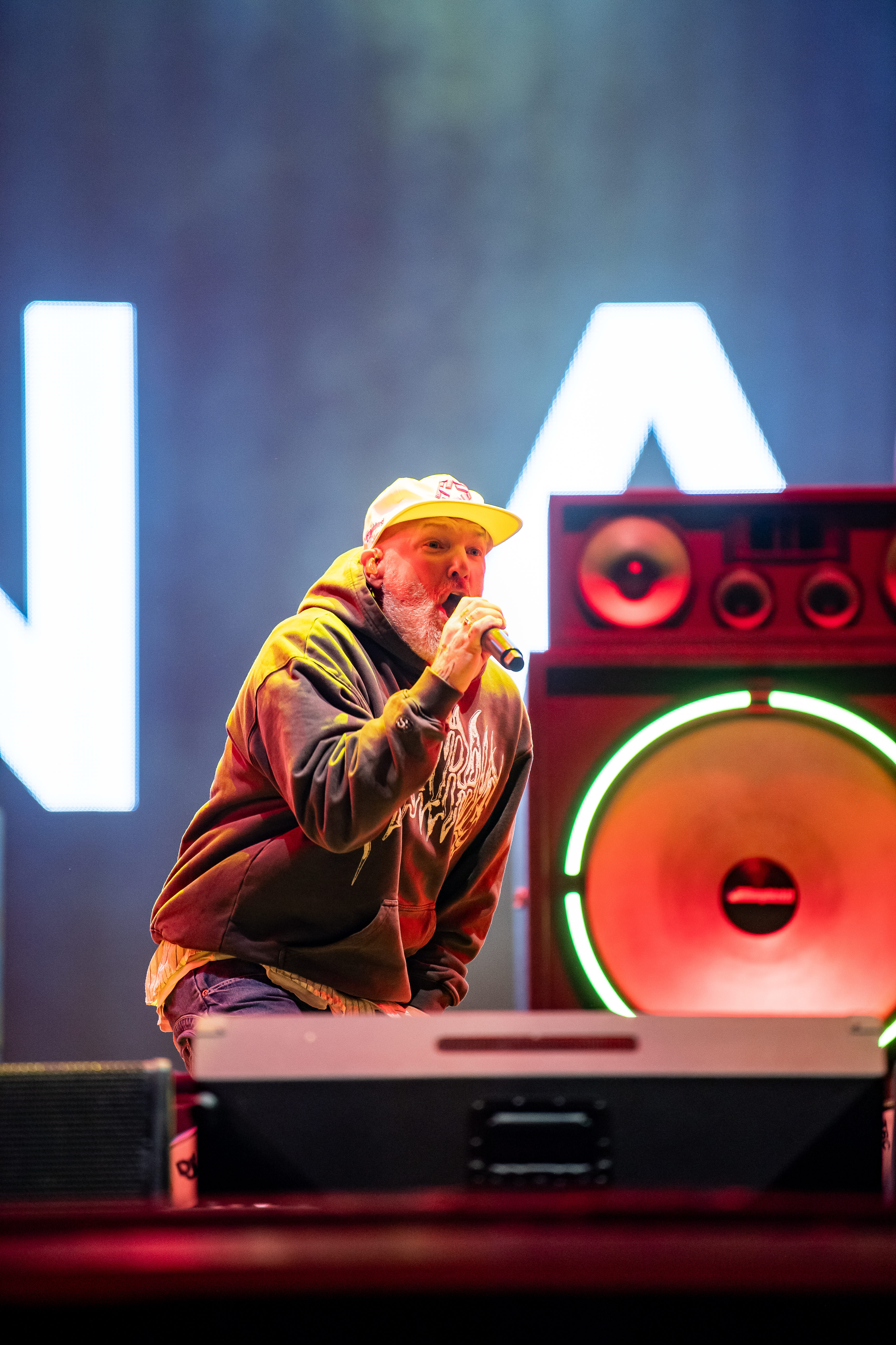 Fred Durst, Sänger von Limp Bizkit in gelber Cap und schwarz-grauem Hoodie mit weißem Schriftzug auf der Mandora Stage mit buntem Bühnenlicht beim Rock am Ring Festival.
Nürburgring, 06. Juni 2026. Foto: Alexander Franz