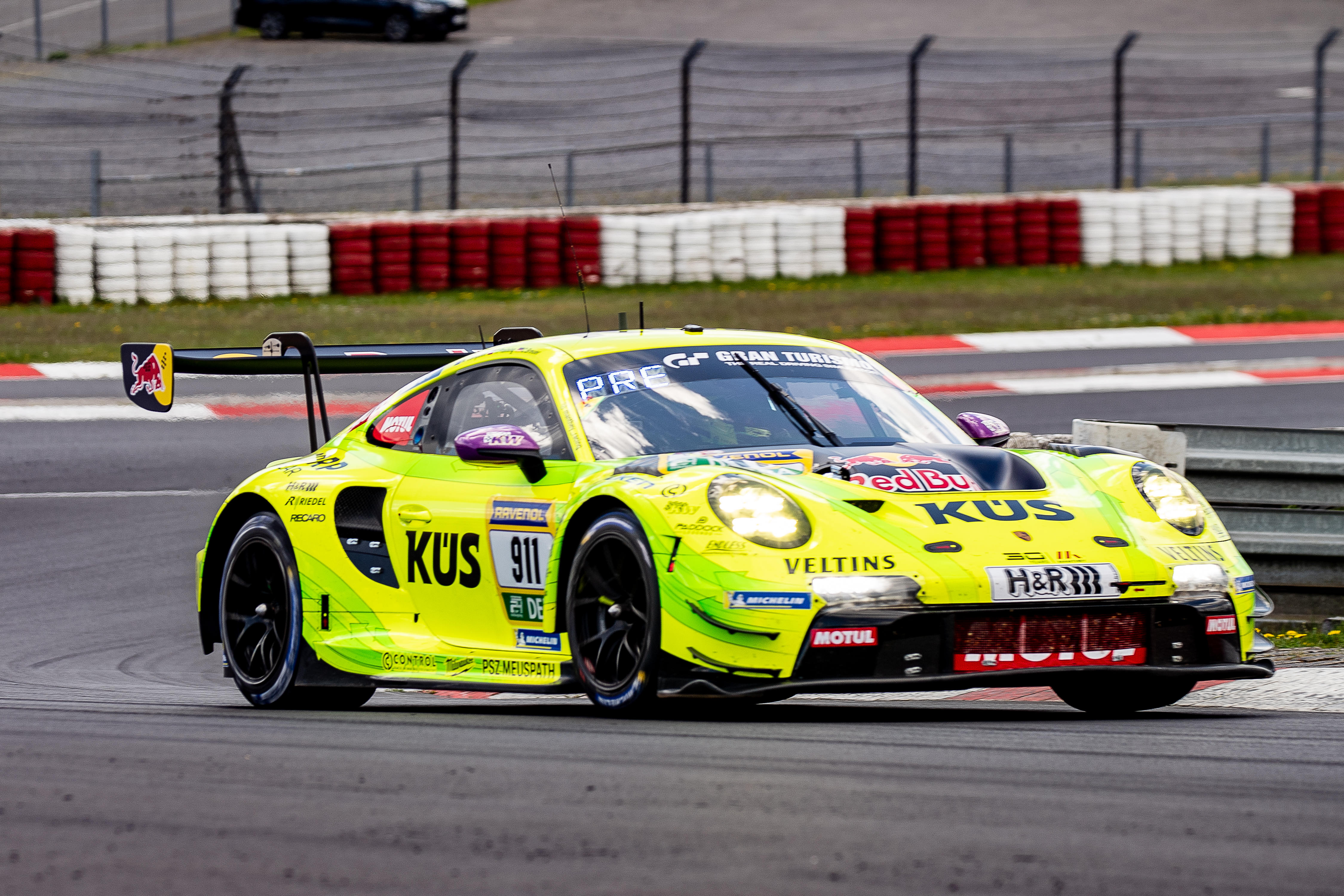 Manthey (#911) SP 9 PRO mit den Fahrern Thomas Preining (AUT), Matt Campbell (USA), Christoph Breuer (GER). Ein gelber Porsche 911 mit der Startnummer 911 fährt auf der Rennstrecke bei den ADAC 24h Nürburgring Qualifiers.