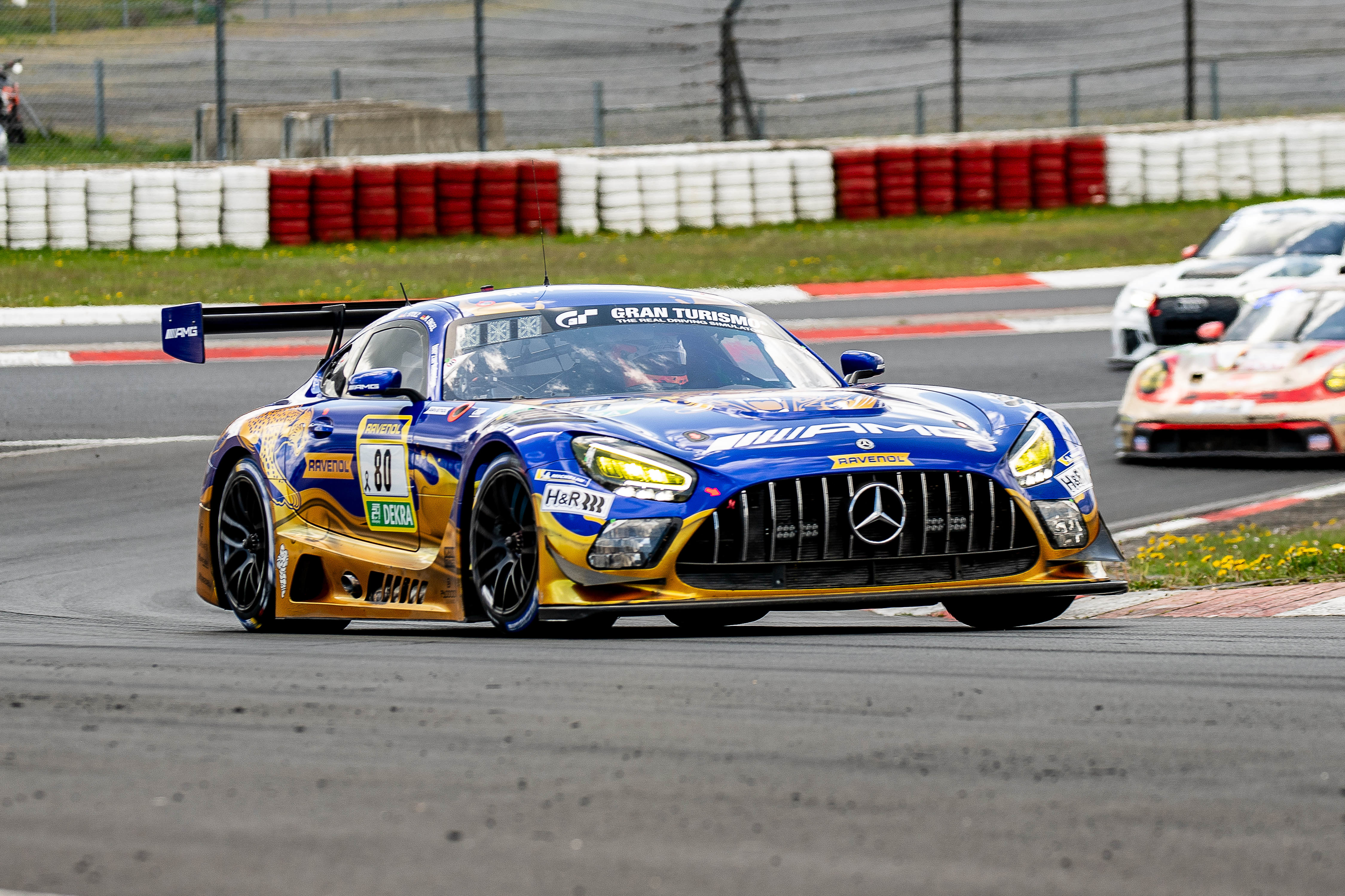 Mercedes-AMG Team RAVENOL (#80) SP 9 PRO mit den Fahrern Maro Engel (MCO), Fabian Schiller (GER), Luca Stolz (GER). Der Mercedes-AMG GT3 #80 fährt auf der Rennstrecke, im Hintergrund sind weitere GT3-Fahrzeuge sichtbar.